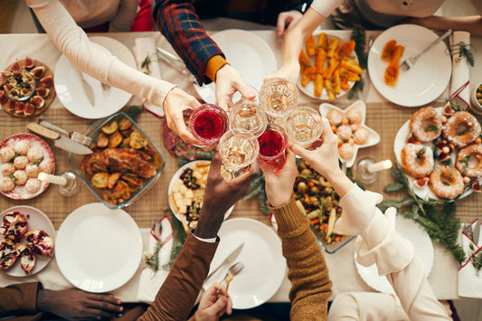 Friends toasting over a table spread with Friendsgiving dishes