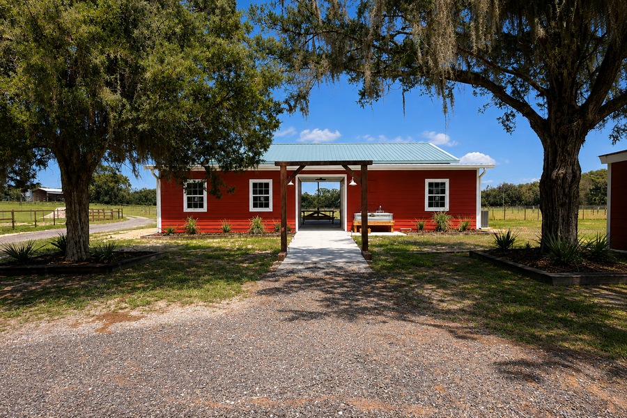 The red event barn at Riverbend Cattle Company, set among the oaks